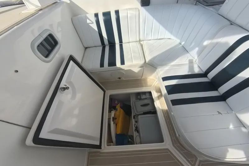 Slide: The Image of 2005 Intrepid 348 Walkaround boat interior with open storage compartment and striped seating. - 43