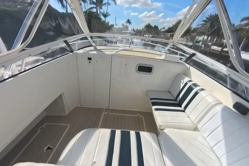 Slide: The Image of 2005 Intrepid 348 Walkaround boat interior with white seating and clear canopy. - 45