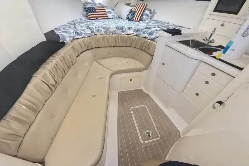 Slide: The Image of 2005 Intrepid 348 Walkaround cabin interior with seating, bed, and kitchenette. - 50