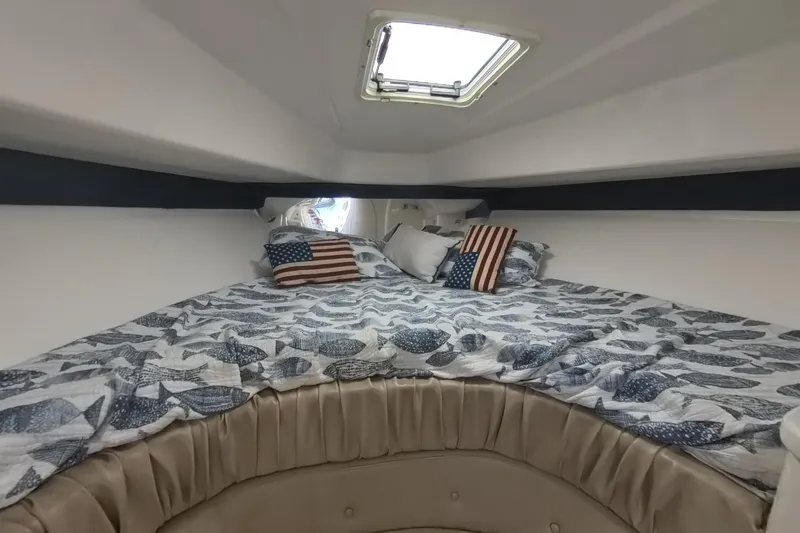 Slide: The Image of Cozy cabin interior of 2005 Intrepid 348 Walkaround with nautical-themed bedding and American flag pillows. - 52