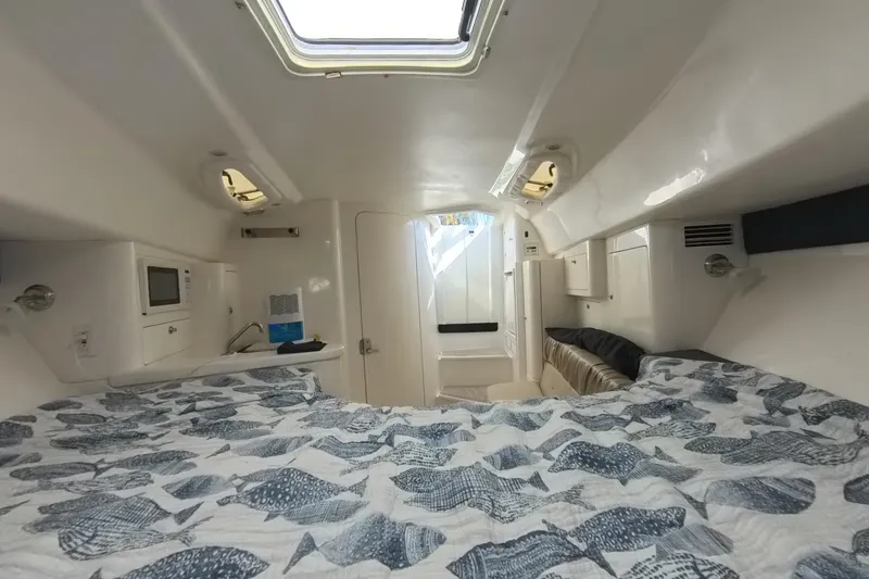 Slide: The Image of Interior of a 2005 Intrepid 348 Walkaround boat, featuring a cozy cabin with a bed. - 53