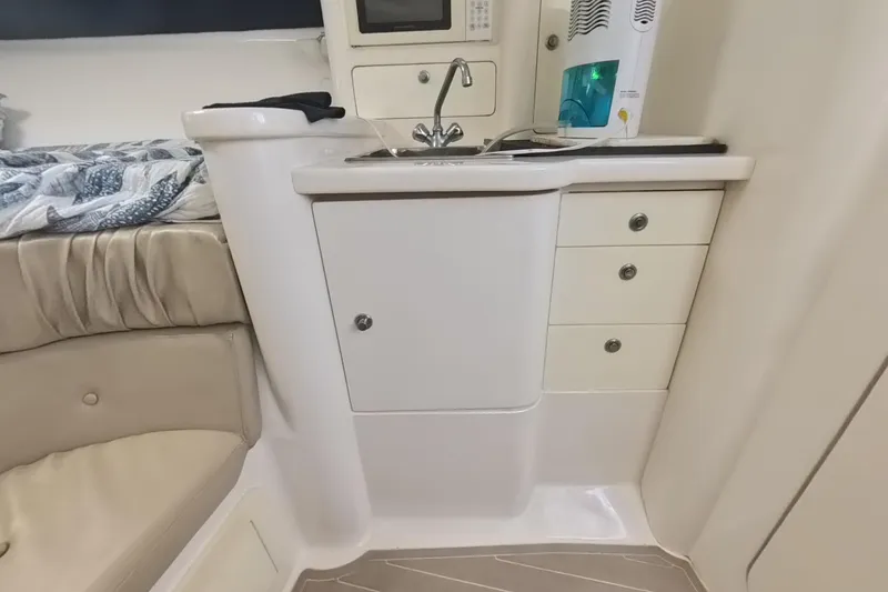 Slide: The Image of 2005 Intrepid 348 Walkaround cabin interior with kitchenette and seating area. - 57