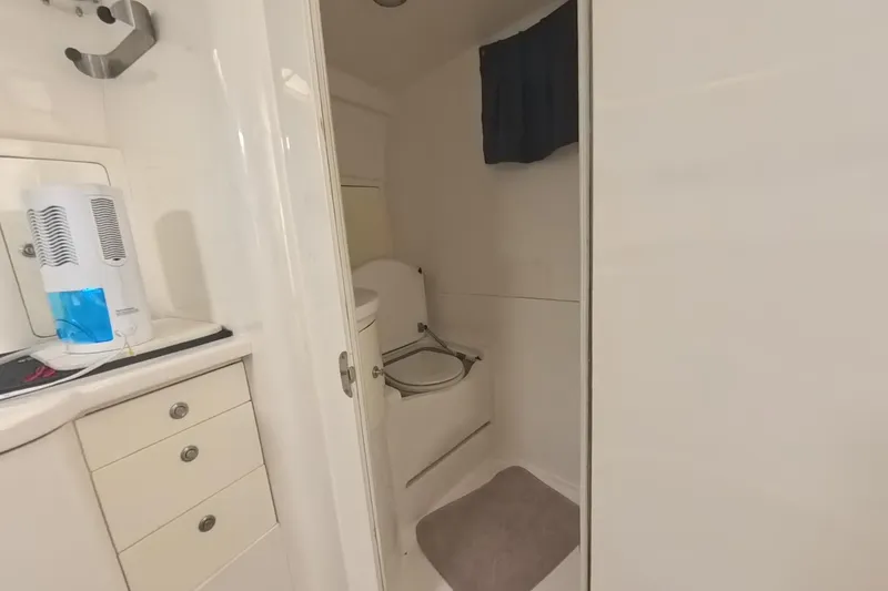 Slide: The Image of 2005 Intrepid 348 Walkaround boat bathroom with white cabinetry and compact toilet. - 59