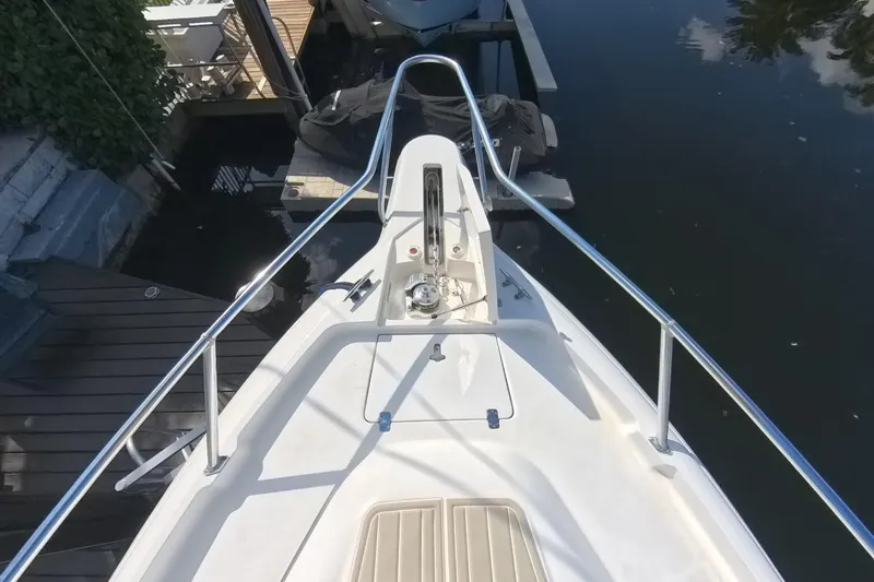 Slide: The Image of Bow view of 2005 Intrepid 348 Walkaround boat docked by the water. - 62