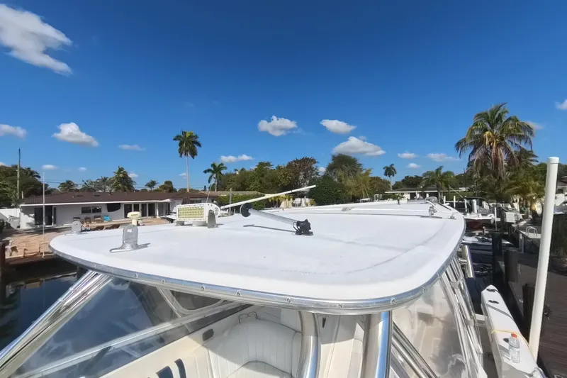 Slide: The Image of 2005 Intrepid 348 Walkaround boat docked under clear blue sky with palm trees. - 64