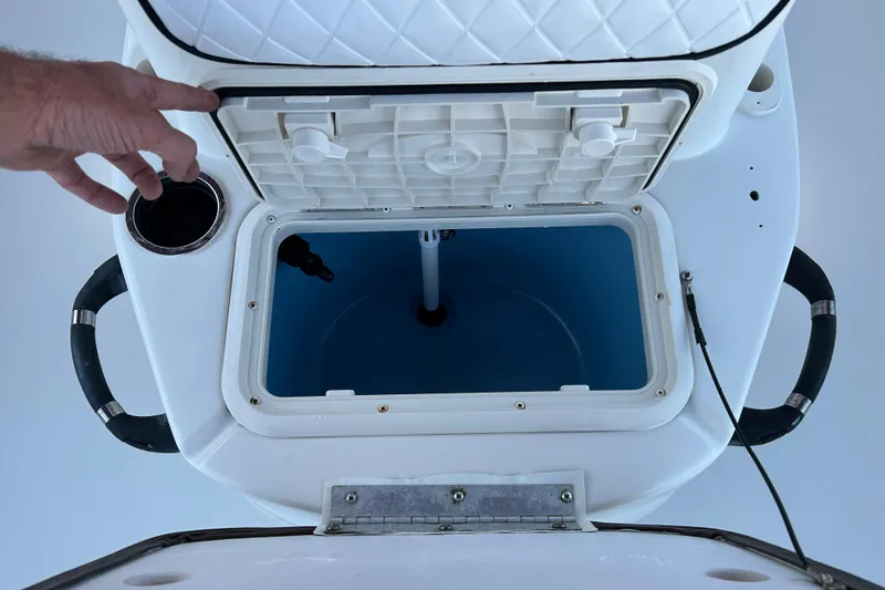 Slide: The Image of Open storage compartment on 2020 Carolina Skiff 21 LS boat, featuring cup holder and handles. - 15