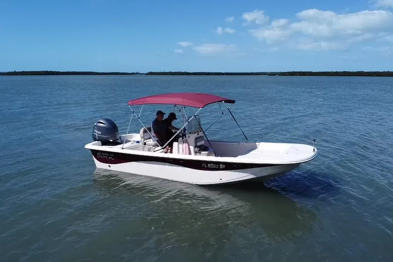 Slide: The Image of 2020 Carolina Skiff 21 LS boat on calm water with red canopy. - 18