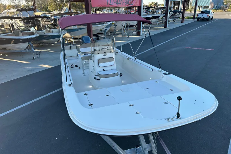Slide: The Image of 2020 Carolina Skiff 21 LS boat with maroon canopy, parked in a marina. - 6