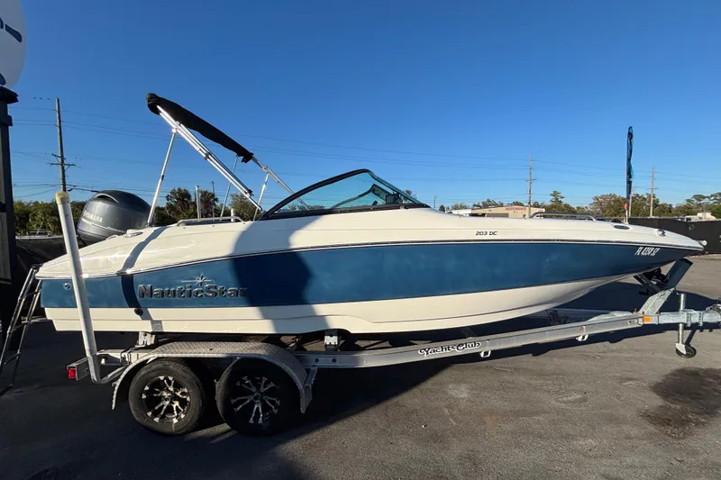 Slide: The Image of 2021 NauticStar 203 DC boat with 115 horsepower engine at a sales lot. - 10
