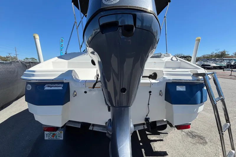 Slide: The Image of 2021 NauticStar 203 DC boat rear view with outboard motor and ladder. - 11