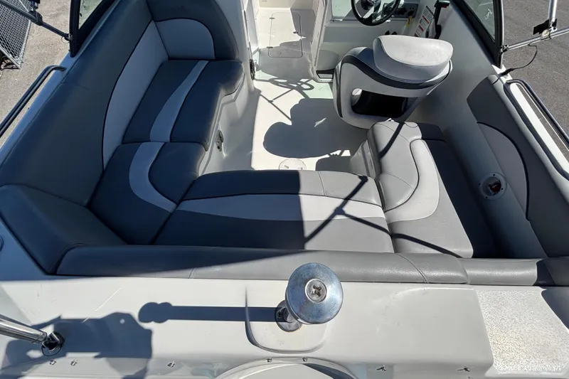 Slide: The Image of 2021 NauticStar 203 DC boat interior with gray seating and steering console. - 18