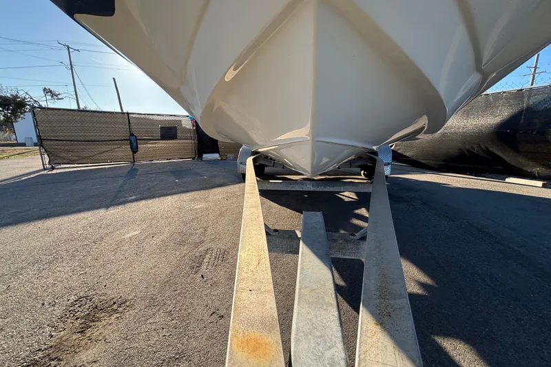 Slide: The Image of 2021 NauticStar 203 DC boat with Yamaha engine on trailer, under clear blue sky. - 2