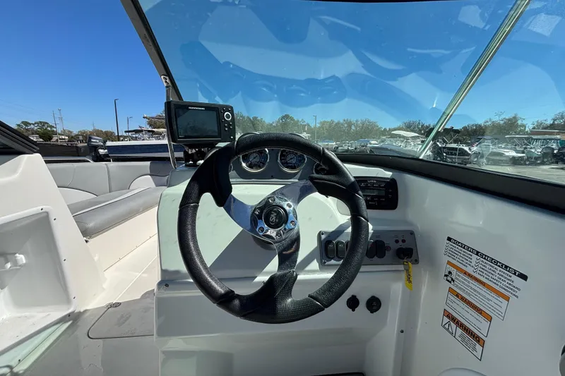 Slide: The Image of 2021 NauticStar 203 DC boat dashboard with steering wheel and navigation system. - 22