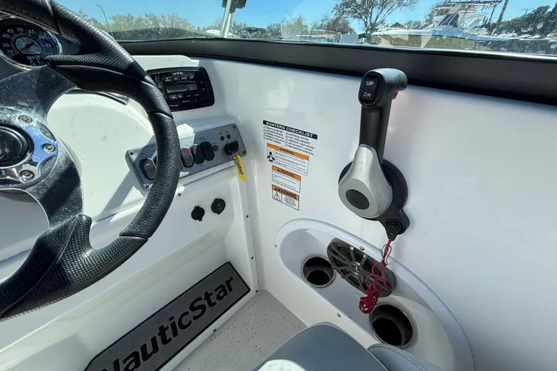 Slide: The Image of 2021 NauticStar 203 DC boat dashboard with steering wheel and control panel. - 27