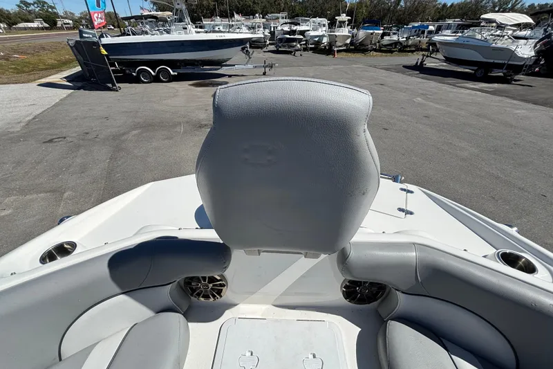 Slide: The Image of 2021 NauticStar 203 DC boat interior with gray seating at a marina. - 38