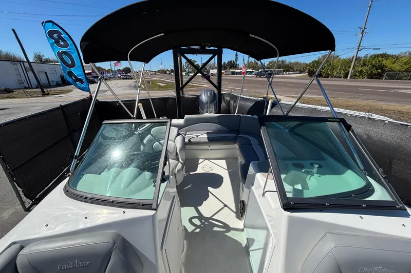Slide: The Image of 2021 NauticStar 203 DC boat with canopy, parked outdoors on a sunny day. - 46