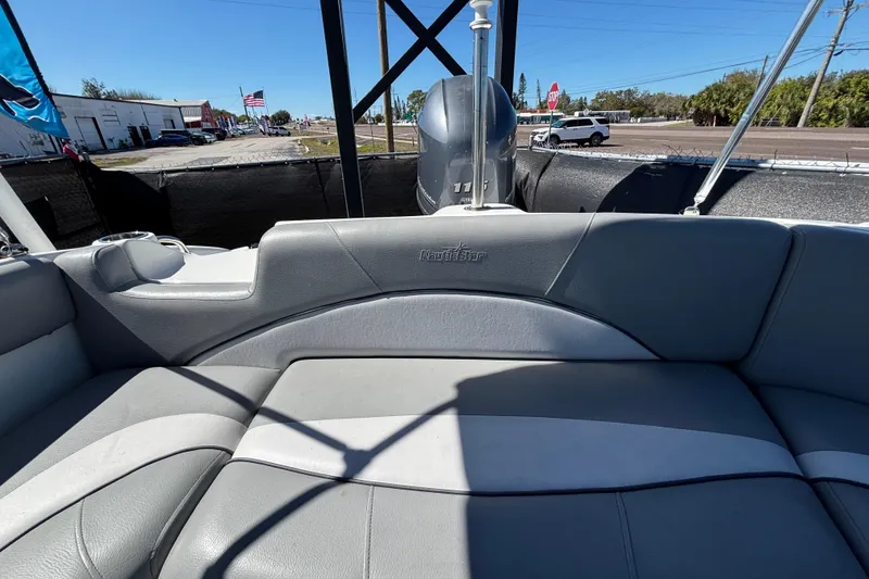 Slide: The Image of 2021 NauticStar 203 DC boat interior with gray seating and outdoor view. - 57