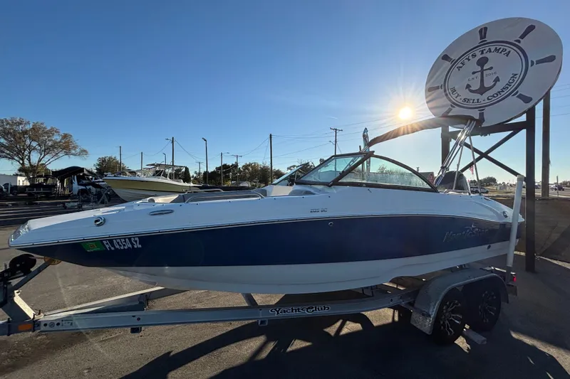 Slide: The Image of 2021 NauticStar 203 DC boat displayed outdoors under clear blue sky. - 6