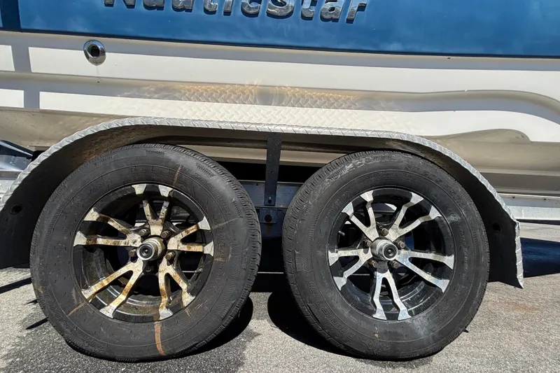 Slide: The Image of Trailer wheels of a 2021 NauticStar 203 DC boat, showing wear and rust. - 67