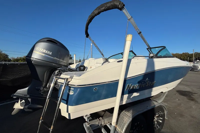 Slide: The Image of 2021 NauticStar 203 DC boat on trailer under clear blue sky. - 9
