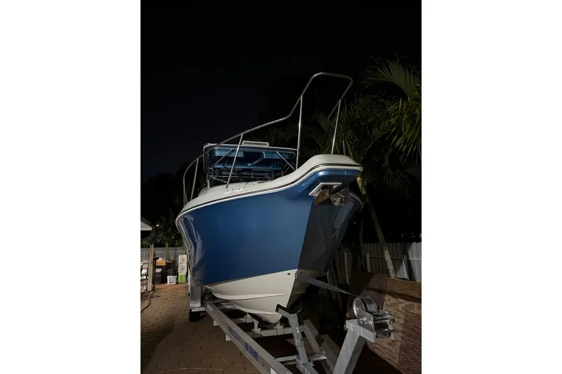 Slide: The Image of 2001 Wellcraft 270 Coastal O/B boat on trailer at night, palm trees in background. - 12
