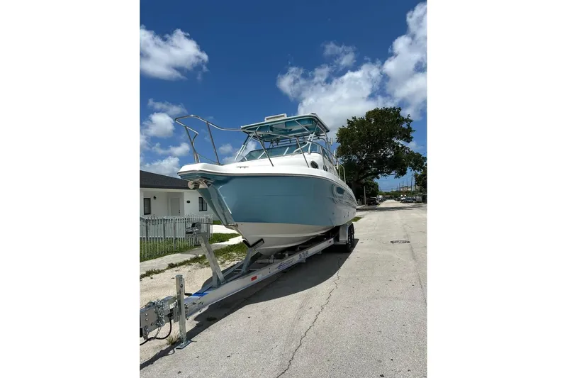 Slide: The Image of 2001 Wellcraft 270 Coastal O/B boat on trailer under blue sky. - 18