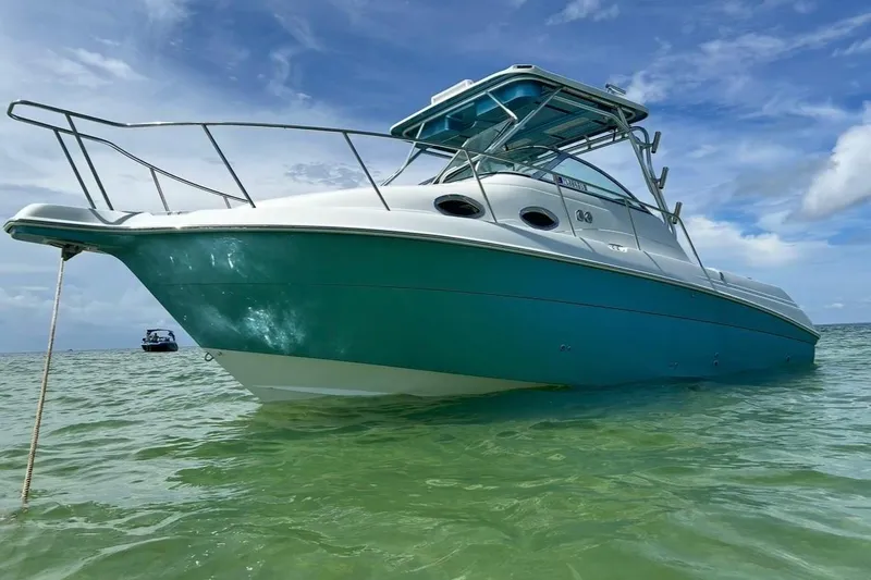 Slide: The Image of 2001 Wellcraft 270 Coastal O/B boat anchored in clear, shallow water under a blue sky. - 4