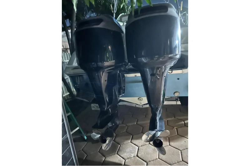 Slide: The Image of Twin outboard motors on a 2001 Wellcraft 270 Coastal boat, parked on a paved surface. - 5