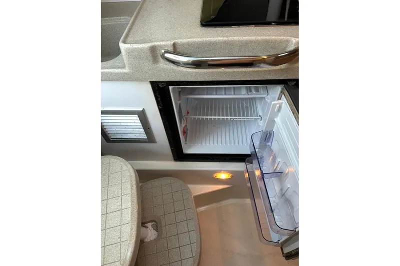 Slide: The Image of Interior of 2001 Wellcraft 270 Coastal O/B showing open mini fridge and countertop. - 7