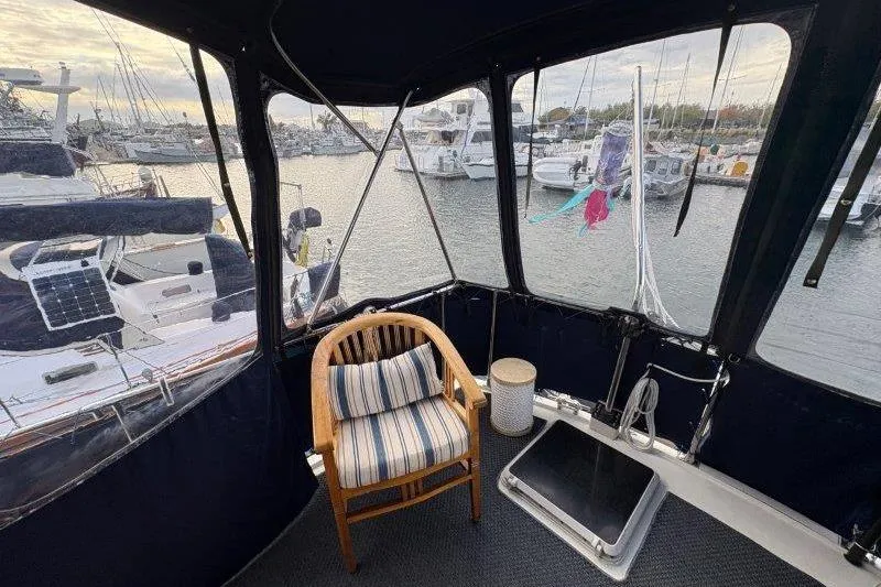 Slide: The Image of 1987 Tollycraft 34 Sundeck Motor Yacht interior with cozy seating and marina view. - 12
