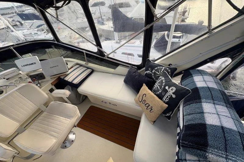 Slide: The Image of 1987 Tollycraft 34 Sundeck Motor Yacht interior with seating and helm, featuring panoramic windows. - 14