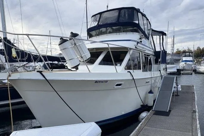 Slide: The Image of 1987 Tollycraft 34 Sundeck Motor Yacht docked at marina under cloudy sky. - 2