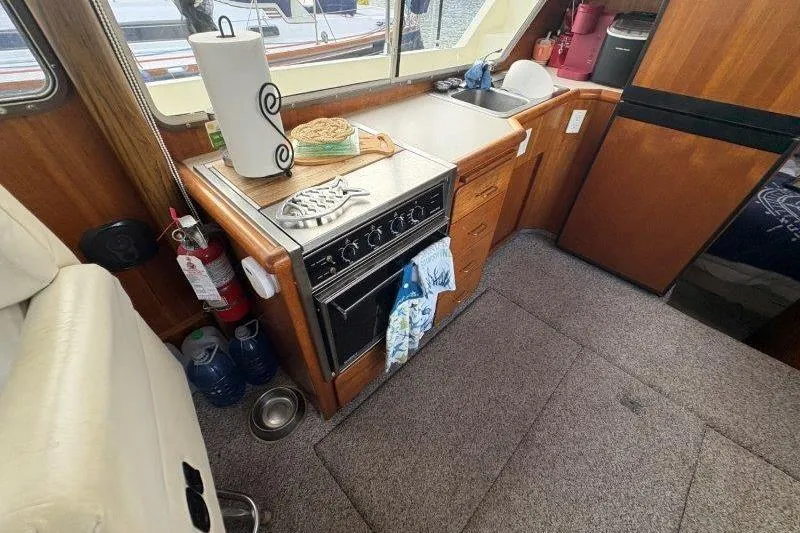Slide: The Image of 1987 Tollycraft 34 Sundeck Motor Yacht interior with kitchen, seating, and marina view. - 33