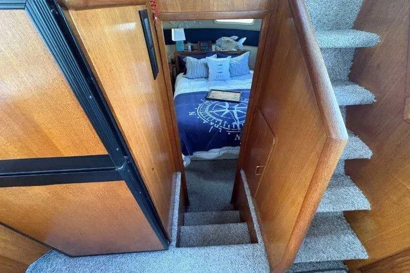 Slide: The Image of 1987 Tollycraft 34 Sundeck Motor Yacht kitchen with stove, sink, and wooden cabinetry. - 34