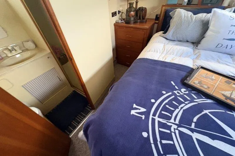 Slide: The Image of 1987 Tollycraft 34 Sundeck Motor Yacht bedroom with nautical decor and cozy bedding. - 38
