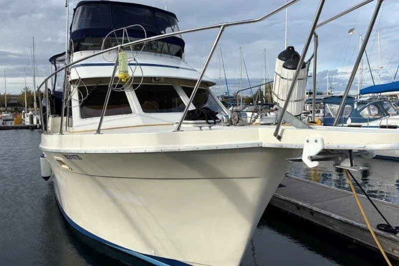 Slide: The Image of 1987 Tollycraft 34 Sundeck Motor Yacht docked at marina, front view. - 4