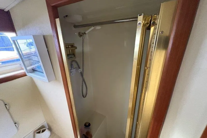 Slide: The Image of 1987 Tollycraft 34 Sundeck Motor Yacht interior with bathroom and wooden cabinetry. - 40