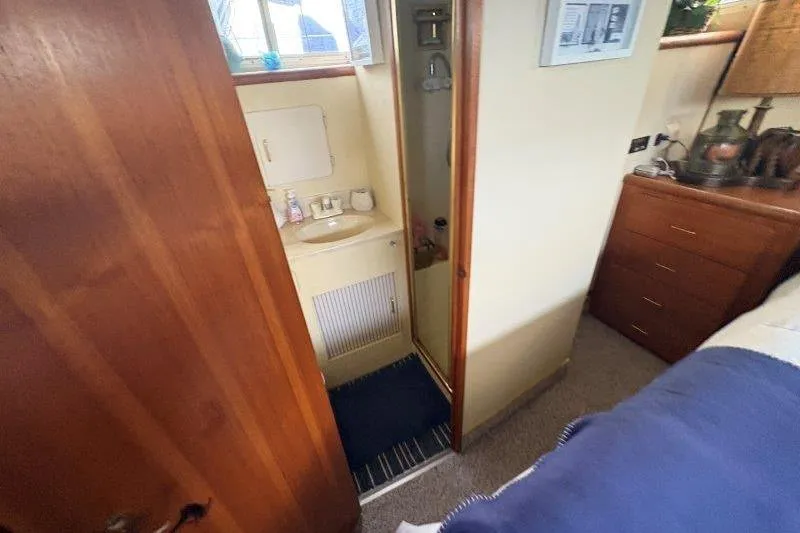 Slide: The Image of 1987 Tollycraft 34 Sundeck Motor Yacht shower with gold trim and handheld showerhead. - 41