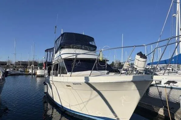 Slide: The Image of 1987 Tollycraft 34 Sundeck Motor Yacht docked in a marina under clear blue skies. - 5
