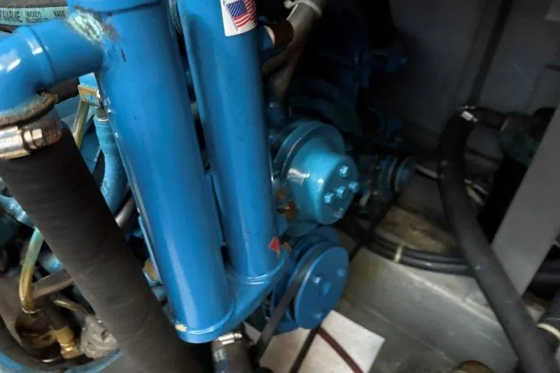 Slide: The Image of Engine compartment of 1987 Tollycraft 34 Sundeck Motor Yacht, featuring blue hoses and components. - 53