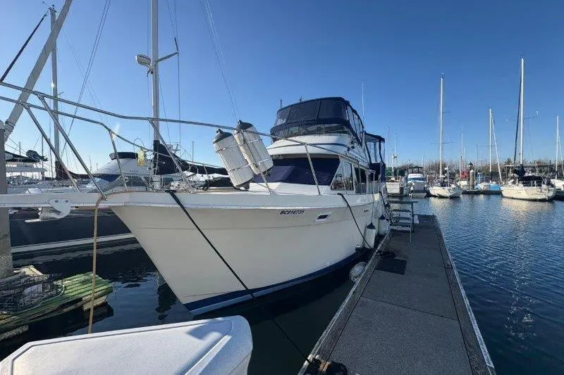 Slide: The Image of 1987 Tollycraft 34 Sundeck Motor Yacht docked at marina under clear blue sky. - 6