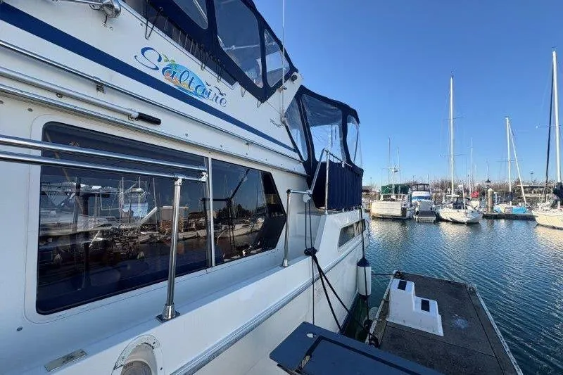Slide: The Image of 1987 Tollycraft 34 Sundeck Motor Yacht docked at marina under clear blue sky. - 7