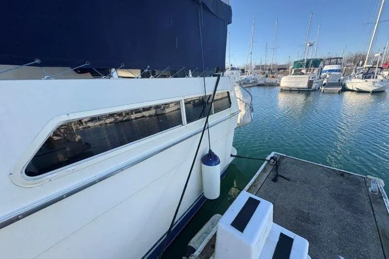 Slide: The Image of 1987 Tollycraft 34 Sundeck Motor Yacht docked at marina, side view. - 9