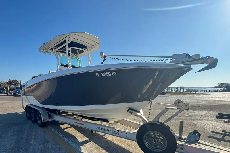 Slide: The Image of 2021 Wellcraft 262 Fisherman boat on trailer, parked near waterfront under clear blue sky. - 15