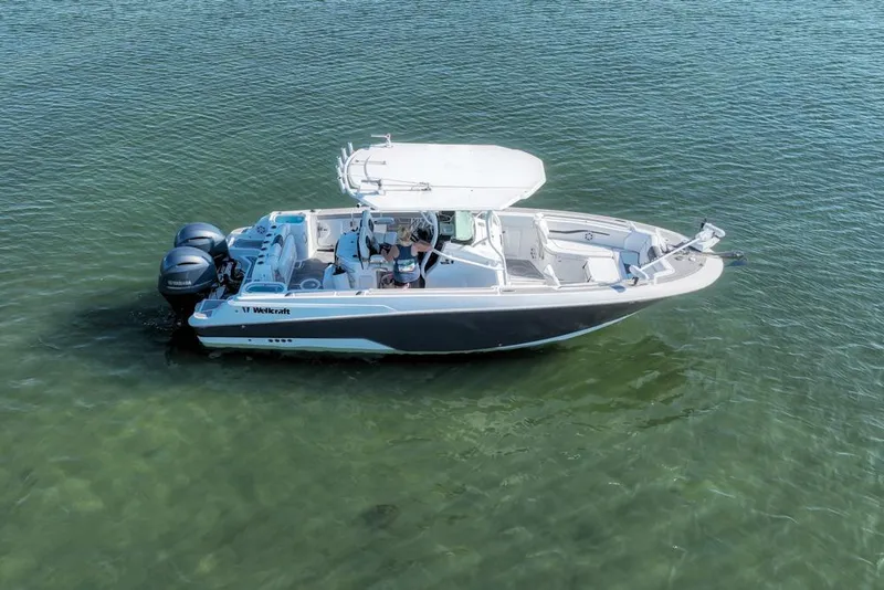 Slide: The Image of 2021 Wellcraft 262 Fisherman boat on calm water, featuring dual outboard engines. - 16