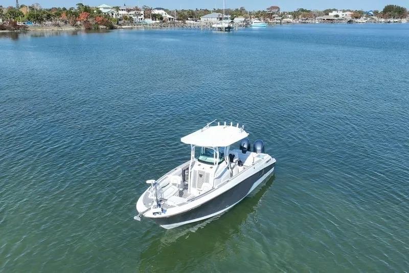 Slide: The Image of 2021 Wellcraft 262 Fisherman boat on calm water near shoreline. - 19