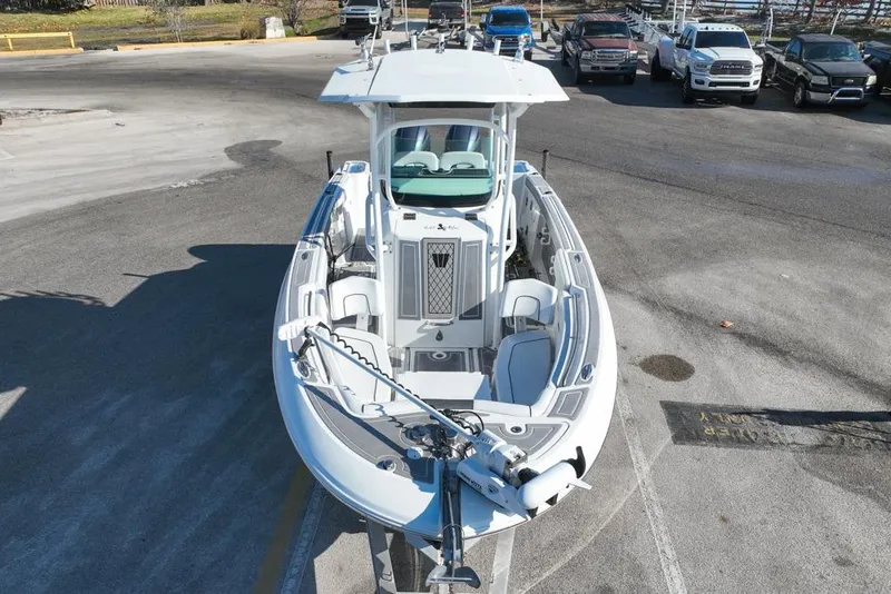 Slide: The Image of 2021 Wellcraft 262 Fisherman boat parked in a lot, viewed from the front. - 2