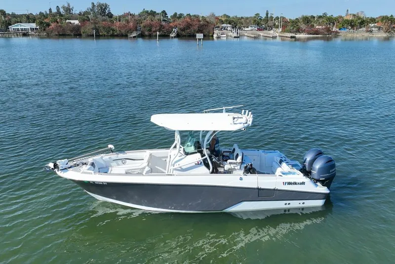 Slide: The Image of 2021 Wellcraft 262 Fisherman boat on calm water, featuring dual engines and sleek design. - 20