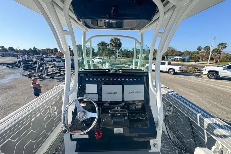 Slide: The Image of 2021 Wellcraft 262 Fisherman boat dashboard with Garmin navigation systems in a sunny marina. - 52