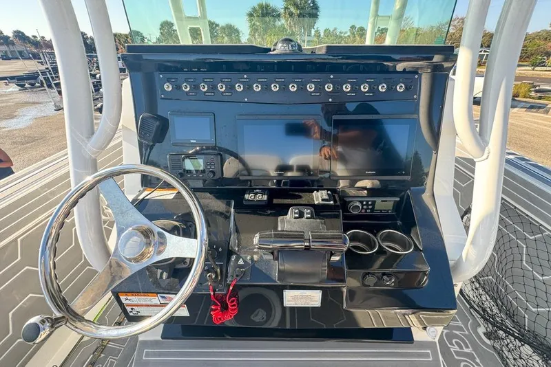 Slide: The Image of 2021 Wellcraft 262 Fisherman boat dashboard with steering wheel and electronic controls. - 54